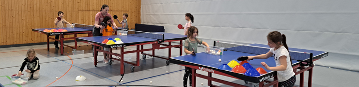 Kinder beim Tischtennistraining in der Sporthalle.